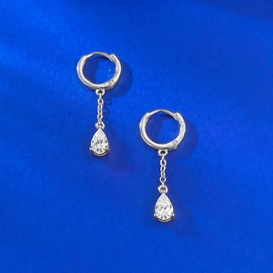 Macro detail of S925 sterling silver hoop earrings with pear-cut cubic zirconia drop charms