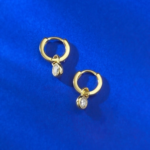 Macro detail of 18K gold plated S925 silver hoop earrings with round bezel-set zircon charms