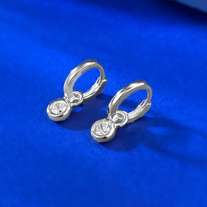 Detail of silver S925 huggie earrings featuring two vertically set round cubic zirconia