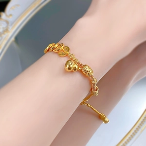 Gros plan d'une gourde dorée et de breloques en pièces sur un bracelet tressé