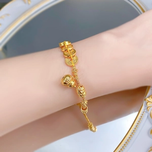 Détail du pendentif gourde Wu Lou dorée et pièces sur bracelet tressé jaune