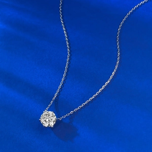 Detail of a 9mm round brilliant-cut solitaire diamond necklace in six-prong silver setting