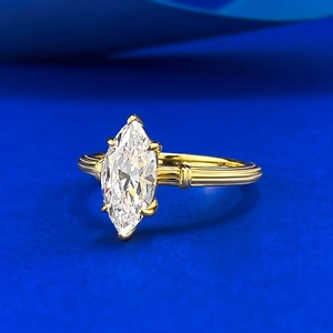 Marquise cut clear gemstone gold ring with vintage twisted rope band on blue background
