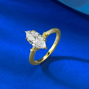 Macro shot of gold vintage marquise cut ring with textured band on blue surface