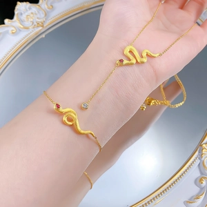 Elegant gold-brushed snake jewelry set with red gemstone eyes and zircon pendant