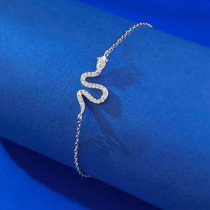 Detailed close-up of a silver snake bracelet featuring sparkling zircon on a blue display