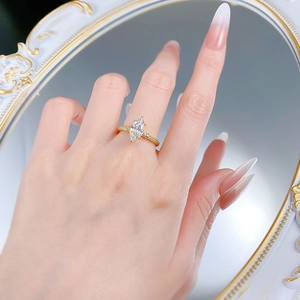 Macro detail of marquise-cut crystal ring with golden textured band on antique mirror