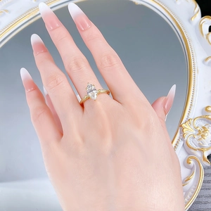 Detail of marquise-cut crystal ring with golden textured band on model's hand