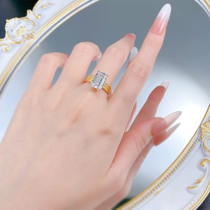 Luxurious gold S925 silver ring with a large emerald-cut emerald stone on a model hand