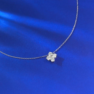 Gros plan du pendentif trèfle à quatre feuilles en argent avec zircon sur velours