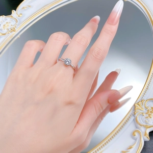 Detail of 6mm round solitaire silver ring with bezel setting shown on finger with mirror