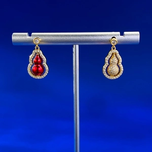Détail de boucles d'oreilles gourde rotatives avec émail rouge et cristaux sertis