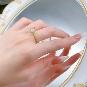 Close-up of a 925 sterling silver gold ring with a large round diamond on a finger