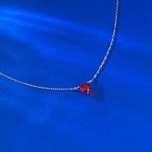 Détail macro du collier en argent S925 avec un pendentif en rubis rouge en cœur
