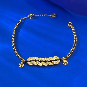 Detailed shot of S925 silver coin bracelet with gold plating and black braided cord