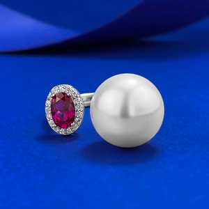 Macro view of S925 silver ring featuring 12mm shell pearl and oval red gemstone