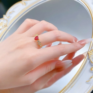Vista macro dell'anello con rubino a cuore e diamanti su uno specchio vintage