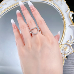 Detail of S925 silver hollow heart ring with white zircon pave setting on a model finger