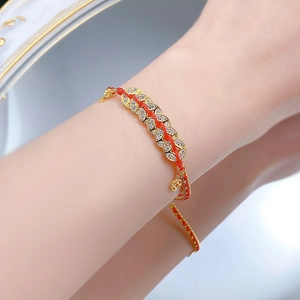 Detailed shot of S925 silver red string bracelet with gold coins and sparkling zircons