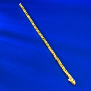 Bracelet tennis classique en or avec zircons jaunes brillants sur fond de tissu en soie
