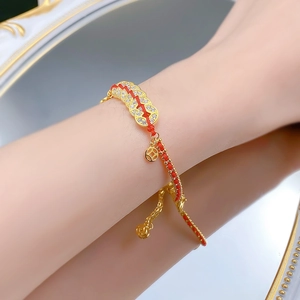 Detail of red string bracelet with gold coin charms on wrist against classic mirror background