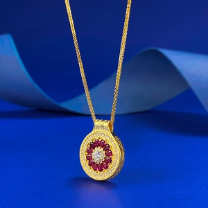 Detailed macro view of S925 silver compass pendant with red gems and gold wheat chain
