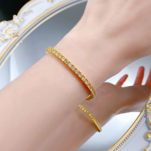 Gros plan d'un bracelet tennis jaune étincelant au poignet avec reflet de miroir