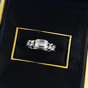 Macro view of emerald-cut rectangular zircon set in a silver Cuban link chain ring band