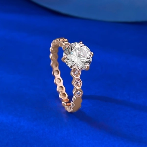 Detail of rose gold ring with six-prong setting and honeycomb band design