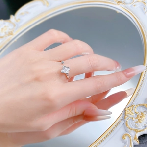 Macro detail of S925 silver clover ring with sparkling zircon stones on a mirror surface