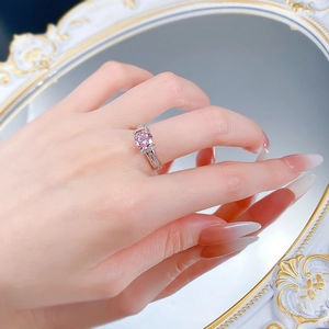 Détail d'une bague en argent S925 avec pierre rose sur main devant un miroir vintage