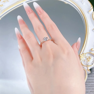 Detail of rose gold S925 silver ring with a sparkling round-cut diamond on a hand