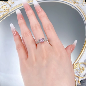 Gros plan d'une bague en argent S925 avec une pierre rose ronde et des diamants pavés