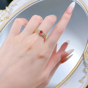 Close-up of S925 silver ring with oval pigeon blood red stone and golden filigree band