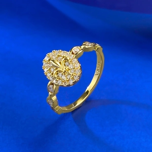 Macro shot of S925 silver gold ring featuring an oval fleur-de-lis pavé-set diamond design
