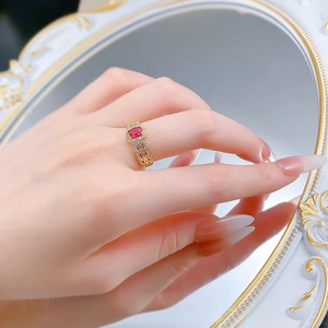 Macro view of vintage gold ring with oval red gemstone and intricate hollow carving