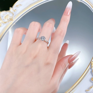 Close-up of S925 silver six-prong round moissanite ring with pave diamond band on finger