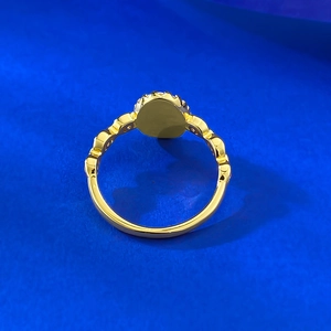 Elegant gold oval iris flower ring with beaded band design on a blue background