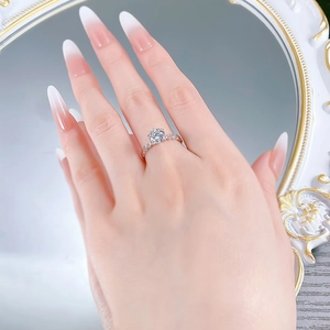 Detail of S925 silver six-prong ring with round diamond on hand before vintage mirror
