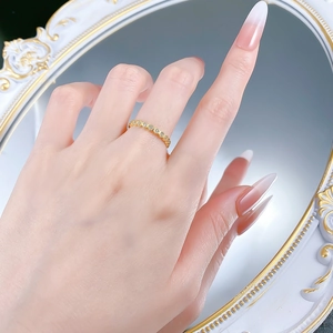 Close-up of a gold-plated honeycomb ring with sparkling diamonds on a hand