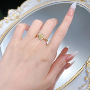 Macro detail of gold oval fleur-de-lis ring with micro-pave zircon crystals