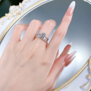 Close-up of a silver S925 ring set featuring a six-prong round moissanite and pave bands