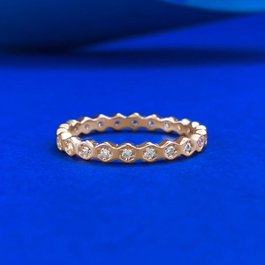 Close-up of rose gold honeycomb eternity ring with pave set sparkling zircons