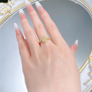 Detail of a vintage oval fleur-de-lis ring with gold plating and pavé-set zircons