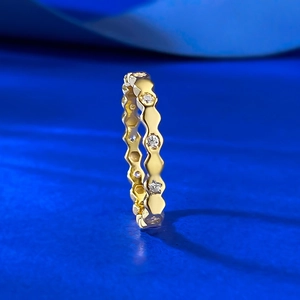 Macro shot of gold honeycomb band featuring micro-inlaid diamonds with geometric wavy edges