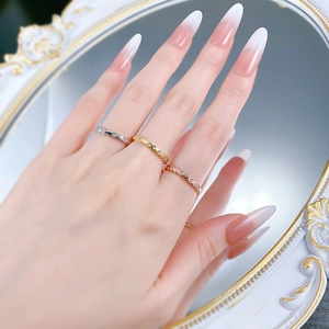 Close-up of three-tone honeycomb rings in silver, gold and rose gold worn on hand