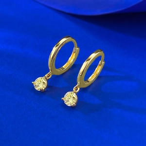 Detail of 18K gold hoop earrings featuring 5mm yellow round-cut stones in four-prong setting