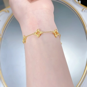 Détail d'un bracelet trèfle doré avec filigrane délicat sur un miroir décoratif