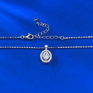 Élégant collier en argent S925 avec pendentif halo ovale sur fond bleu texturé