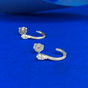 Macro shot of S925 sterling silver stamp on marquise cut diamond J-shaped stud earrings